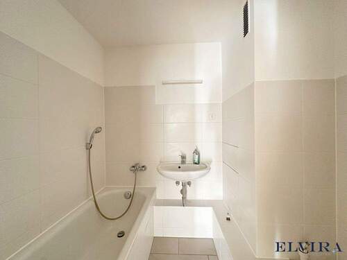Badezimmer mit Badewanne und Waschmaschinenanschluss - 