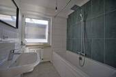 das Badzimmer mit Wanne und Fenster - 