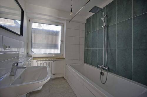 das Badzimmer mit Wanne und Fenster - 