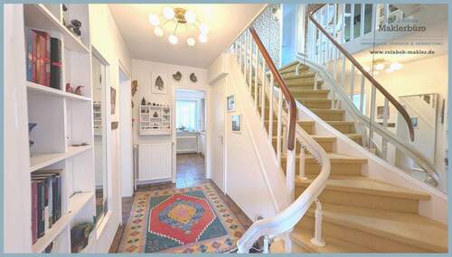 Heller Eingangsbereich mit geschwungener Treppe - 