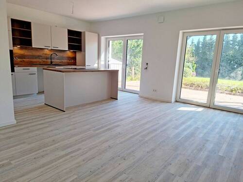 Wohnzimmer mit integrierter EBK und Kochinsel - 3 Zimmer Terrassenwohnung in Schneverdingen