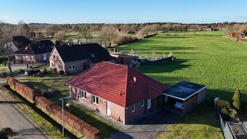 Blick zum Haus, eingebettet in grüner Landschaft ( - Einfamilienhaus mit 106,70 m&sup2; in Aurich zum Kaufen