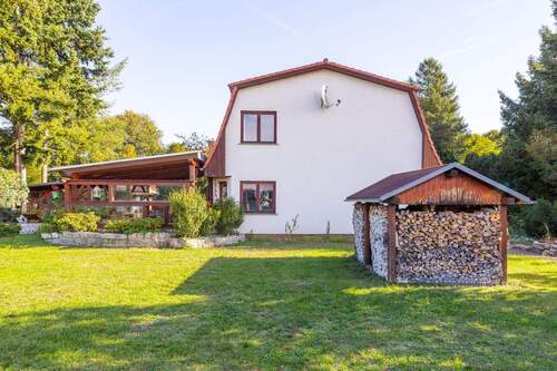 Haus mit Terrasse und Holzlager - 