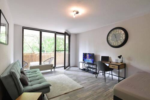 Wohnzimmer mit Balkon - Möbliertes Apartment mit großer Küche, Balkon und Tiefgarage in Mainz-Finthen