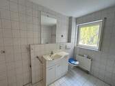 Badezimmer mit Waschmaschinenanschluss, Waschbecken, Badewanne, Dusche und WC - 