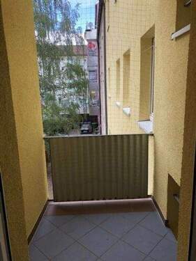 Balkon mit Blick in den grünen Hinterhof - 