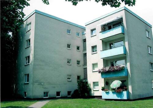 Am Mühlenacker 8, Außenansicht über die Grünanlage mit altem Baumbestand auf den EIngangsbereich eines mehrgeschossigen Wohngebäudes mit Flachdach.JPG - Familienfreundliche 4-Zimmerwohnung in zentraler Lage von Altenbauna
