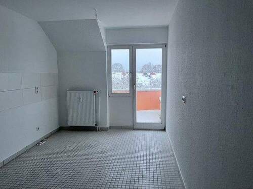 Ansicht Küche mit weißen Fliesenspiegel und Zutritt auf den Balkon - 2 Zimmer Etagenwohnung in Baunatal