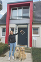 deichhaus foto frau zeigt auf haus mit hunden.png - 