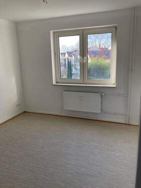 Kinderzimmer mit weiß angelegten Wänden und hellem Vinylboden - 