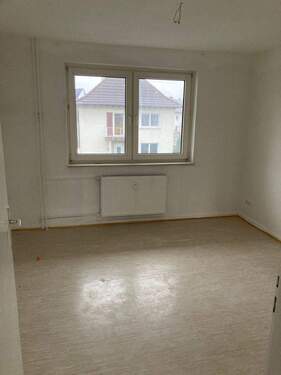 Schlafzimmer mit weiß angelegten Wänden und hellem Vinylboden - 