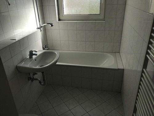 Bad mit Fenster und weißen Fliesen und weißen Sanitärobjekten - Etagenwohnung mit 54,70 m&sup2; in Bad Vilbel zur Miete