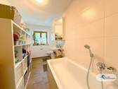 Badezimmer mit Wanne und Waschmaschinenanschluss - 