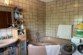 Badezimmer mit Wanne und Fenster - 