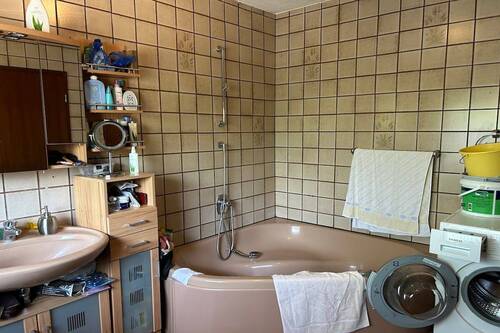 Badezimmer mit Wanne und Fenster - 