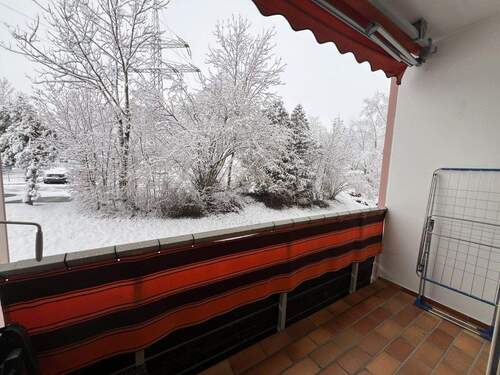 Gemütlicher Balkon mit Winterblick auf verschneite Naturlandschaft - 