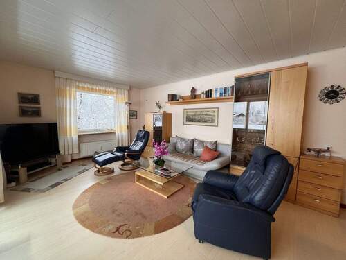 Gemütliches Wohnzimmer mit durchdachter Raumaufteilung und fest verbauten Stauraummöbeln - 3 Zimmer Etagenwohnung in Bad Füssing