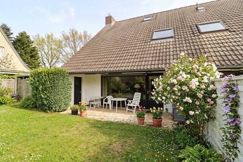 Blick vom Garten auf die Terrasse mit der Garagentür - Familienfreundliche Doppelhaushälfte mit Garage, Carport und schönem Garten in Henstedt-Rhen