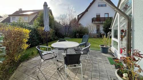 Sonnige Terrasse mit Sitzplatz, ideal für ein gemütliches Frühstück oder entspannte Abende im Garten - 