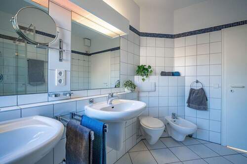 Der Raum ist klassisch weiß gefliest und mit zwei - 