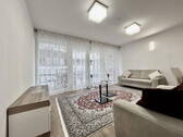 Wohnzimmer mit Fensterfront - Attraktive Eigentumswohnung mit Südbalkon und komplettem Mobiliar
