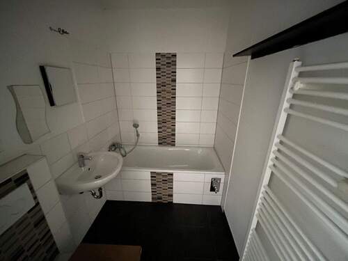 Badezimmer mit Wanne und Handtuchheizkörper - 