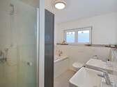 Badezimmer mit Duschkabine, Badewanne und Doppelwaschbecken - 