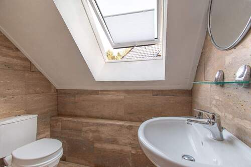 Modernes Bad mit Natursteinoptik und großzügiger Fensterfläche - 