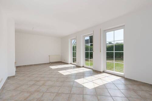 Der lichtdurchflutete Wohnbereich mit bodentiefen Fenstern - 