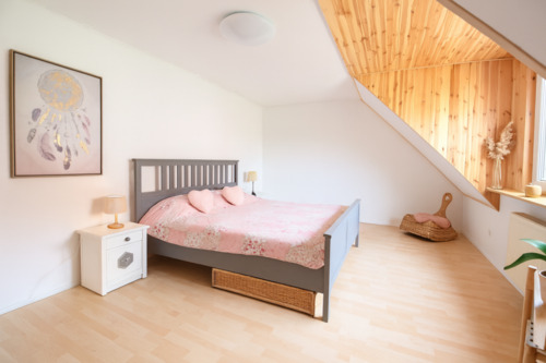 Schlafzimmer mit Holzdecke und floralen Akzenten - 
