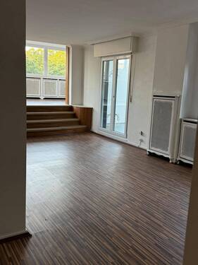 Lichtdurchfluteter Wohnbereich mit eleganter Ebenengestaltung und großzügiger Fensterfront - 