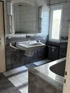 Modernes Tageslicht-Badezimmer mit großzügiger Waschtisch-Lösung und praktischem Granitablageboard - 