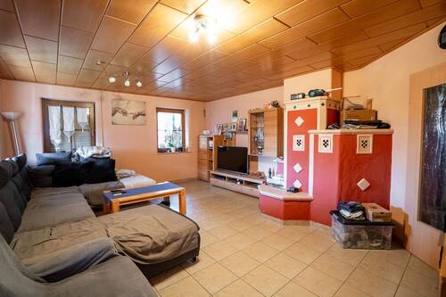 Wohnzimmer mit Kachelofen - Einfamilienhaus mit 160,00 m² in Ermershausen zum Kaufen