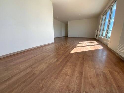 Blick von in Wohnraum mit braunem PVC-Boden und weißen Wänden mit weißen ebenerdigen Fenstern und weißer Balkontür - Etagenwohnung mit 98,80 m&sup2; in Meerbusch zur Miete