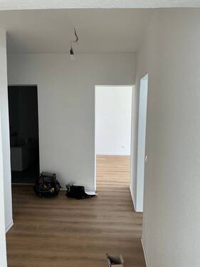 Flur mit neuem Bodenbelag in Holzoptik, Wände in weiß angelegt - 