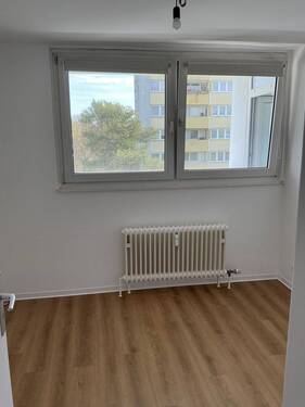 Kinderzimmer mit neuem Bodenbelag in Holzoptik, Wände in weiß angelegt - 