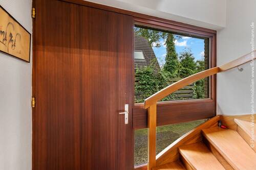 Windfang im Eingangsbereich mit Echtholztreppe ins Dachgeschoss. - 