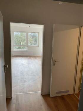 Flur mit Bodenbelag in Holzoptik, Wände weiß angelegt - 