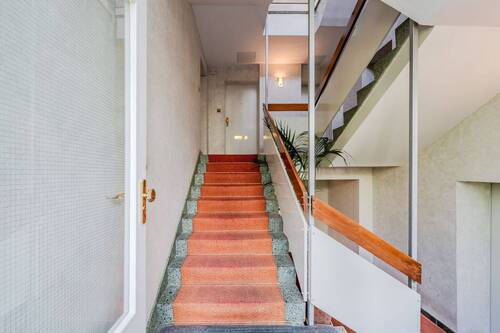 gepflegtes Treppenhaus mit rotem Teppich - 