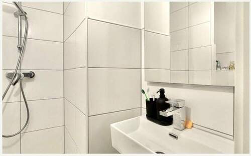 Duschbad mit weißen Fliesen - 2 Zimmer Etagenwohnung in Essen