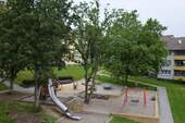 Blick auf den Spielplatz Birkenallee 37 mit Röhrenrutsche und diversen Spielgeräten für Kinder bis 8 Jahre - 3 Zimmer Etagenwohnung zur Miete in Baunatal
