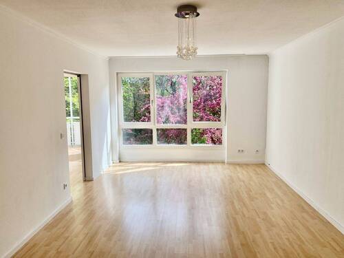 Wohnzimmer mit Schiebetür zur Küche - 2 Zimmer Etagenwohnung in München-Johanneskirchen