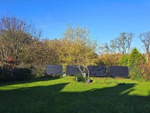 Weitläufige Grünfläche mit Solarpaneelen und Privatsphäre - 