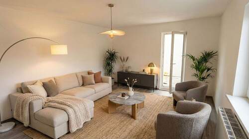 Wohnzimmer Beispiel - Zukunftssicher mit Wärmepumpe und Dämmung - Grüne 2-Zimmer-Wohnung mit Balkon