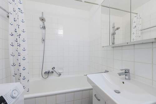 Badezimmer mit Wanne und Waschmaschinenanschluss - 