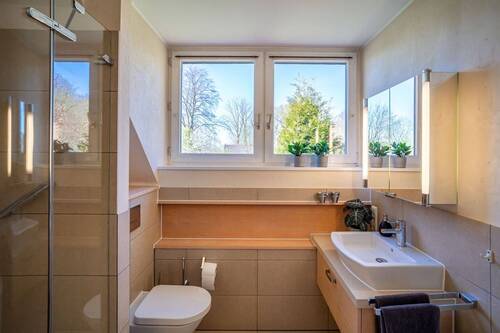 Das dazugehörige Bad ist in warmen Sandtönen gefliest... - 