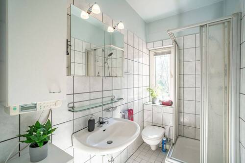 Die Schlafzimmer im Obergeschoss teilen sich ein weiß gefliestes Duschbad. - 