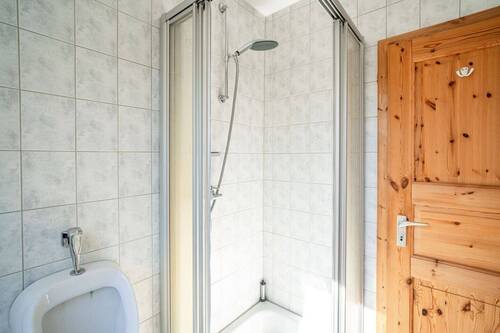 Der Raum ist zeitlos weiß gefliest. - 