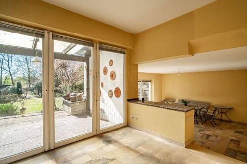 Der abgesenkte Wohnbereich im Anbau ist dank bodentiefer Fenster hell und freundlich. - 