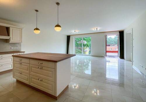 Wohnzimmer mit Balkon und offener Küche - 